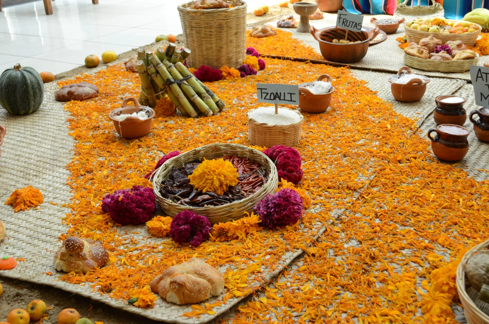 Ofrenda tradicional de Día de Muertos con flores de cempasúchil, pan de muerto y frutas