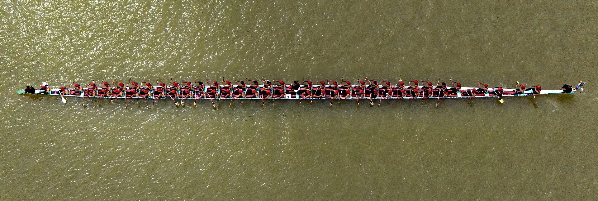 Aerial view of a jalur boat with dozens of rowers during Pacu Jalur in Riau, Indonesia
