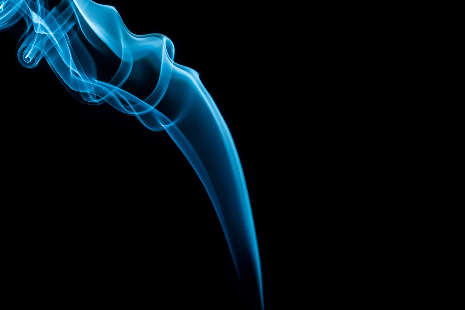 Espiral de fumaça azul iluminada sobre fundo preto, representando a aura azul